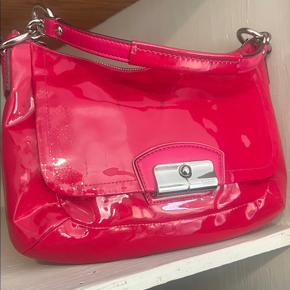 Coach Kristin in a Raspberry shiny Satchel with bit lock.
